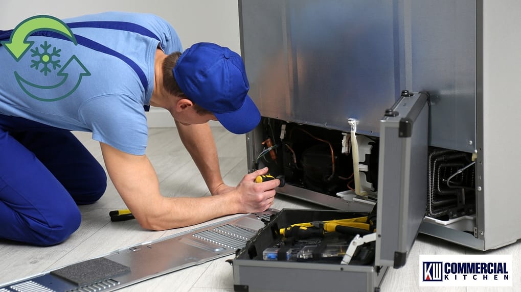 Technician installing and ventilating a commercial fridge with rear access open to the compressor and condenser—Australia site setup.