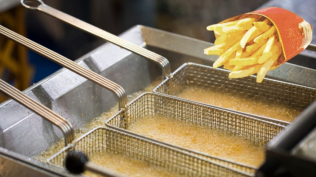 Chef filtering oil and closing the lid of an ENERGY STAR commercial deep fryer to reduce idle energy and extend oil life in an Australian kitchen